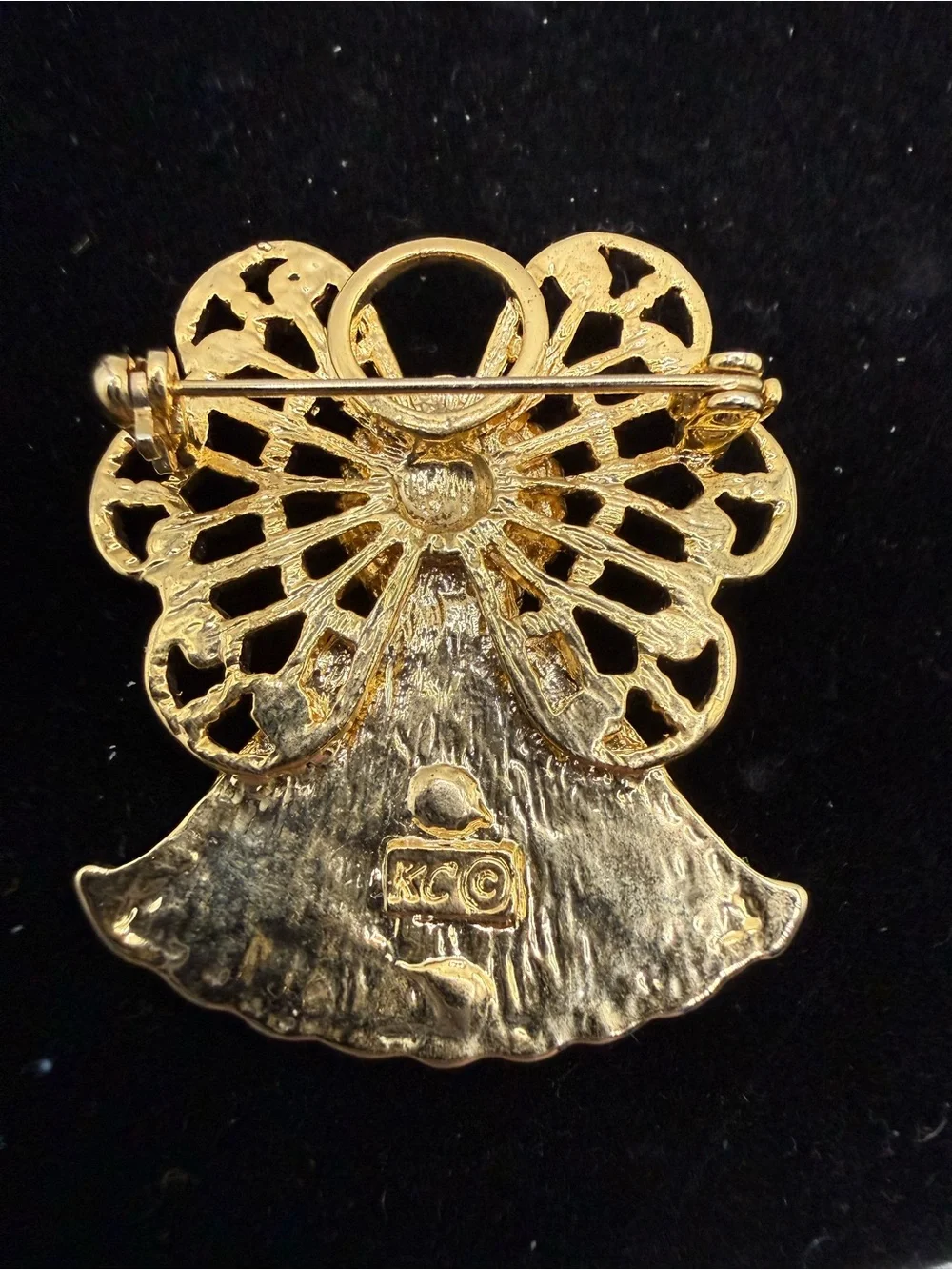 vintage gold-tone angel brooch features a filigree halo, a blue cabochon stone…